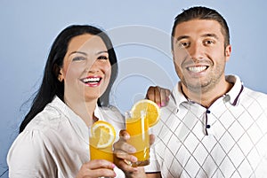Laughing healthy couple with oranges juice