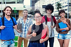 Laughing hipster girl with group of multi ethnic students in city