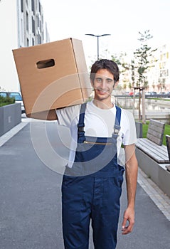 Laughing hispanic worker carries a box