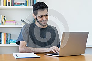 Laughing israeli IT specialist at work at computer