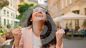 Laughing joke toothy smiling cheerful happy woman Indian Arabian female girl lady outside street town. Joyful hope