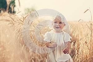 Laughing kid in sunny wheat field