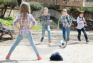 Laughing kids playing street football outdoors