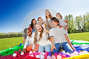 Laughing kids sitting in the center of parachute