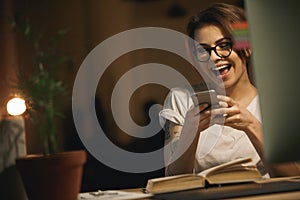 Laughing lady designer sitting indoors at night chatting