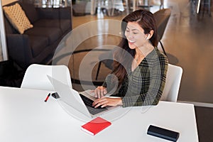 Laughing lady with netbook in workspace