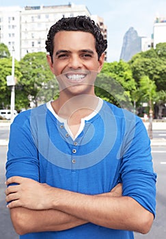 Laughing latin guy with crossed arms in the city