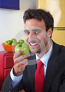 Laughing latin man eats an apple