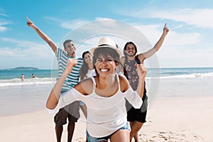 Laughing latin woman with cheering young adults at beach