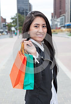 Laughing latin woman with two shopping bags