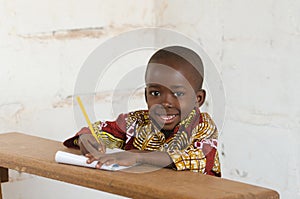 Laughing Little African School Boy Sitting in Desk Smiling at Ca