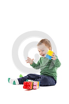Laughing little boy playing with colorful blocks