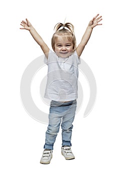 Laughing little girl hands up. Kid 2 years old in jeans and a white T-shirt. Childhood, happiness and positivity. Full height.