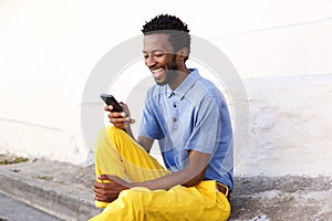 Laughing man holding smart phone looking at text