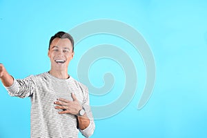 Laughing man taking selfie on color background