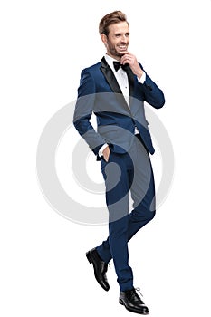 Laughing man walking with hand in pocket and thinking