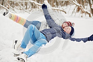 Laughing man and woman lie in snowbank at winter