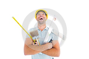 Laughing manual worker holding various tools