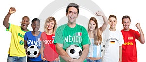 Laughing mexican soccer supporter with ball and fans from other