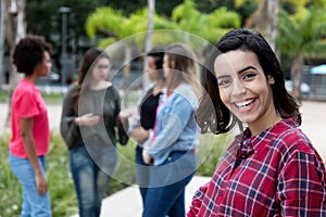 Laughing mexican young adult woman with girlfriends