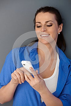 Laughing mid-adult woman texting