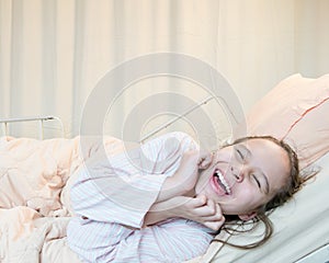 Laughing mixed race tween girl in hospital bed