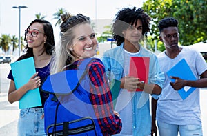 Laughing northern european female student with group of friends