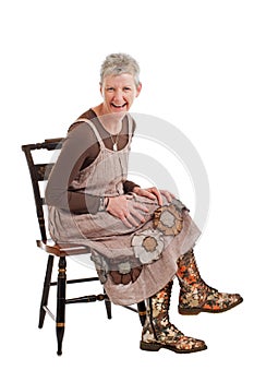 Laughing older woman sits and leans forward