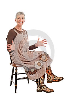 Laughing older woman sits sideways hands open