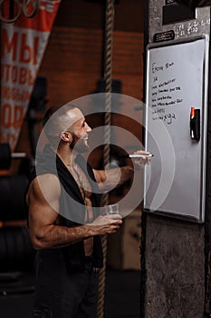 Laughing personal trainer holding a glass of water