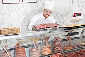 Laughing professional cook laying out food