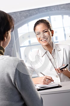 Laughing receptionist with client