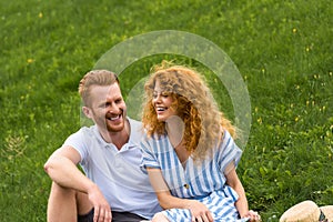 laughing redhead woman sitting with boyfriend