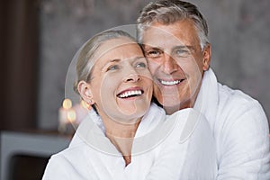 Laughing senior couple embracing at spa