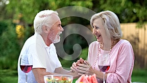 Laughing senior couple having fun during dinner, positive emotions, happiness