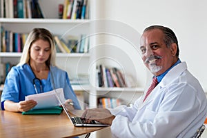 Laughing senior general practitioner with nurse photo