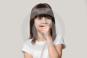 Laughing shy cute girl isolated on grey studio background