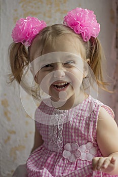 Laughing small kid. Happy little girl 3-4 years old on the background of the old wall