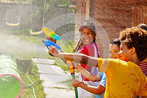 Girl smile holding water gun in group kids game