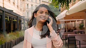 Laughing smiling woman Indian Arabian ethnic happy female girl businesswoman student talking mobile phone call telephone