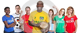 Laughing soccer supporter with drum and fans from other countries