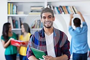 Laughing spanish male student with group of students