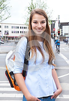 Laughing student with blond hair in the city