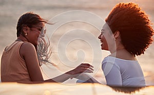 Laughing, sunset and couple of friends by beach with funny joke and bonding on travel with wind. Love, vacation and