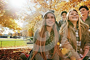 Laughing, talking and friends outdoor in park for relaxing day on summer vacation of semester break, together and photo