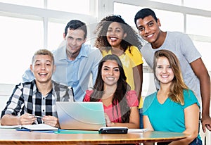 Laughing teacher with multicultural group of students photo