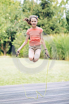 Laughing teenage girl jumping rop