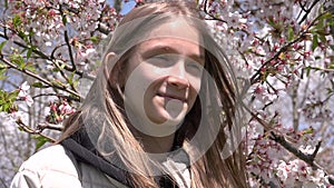 Laughing Teenager Kid by Spring Blossom Tree in Park, Adolescent Girl Smiling by Flowers, Happy Young Child Portrait Laughs