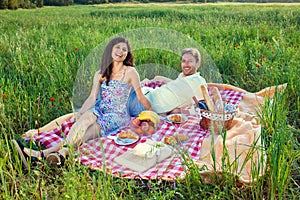 Laughing vivacious couple on a summer picnic