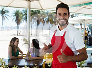 Laughing waiter of a cocktail bar at beach